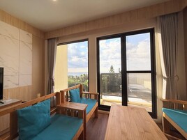 Habitación cuádruple exclusiva, vistas al mar | Zona de estar | Televisión de pantalla plana de 55 pulgadas con canales digitales