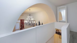 Een modern interieur met een wit gewelfd plafond, een kroonluchter en een inlijsting gezet foto van een gebouw.