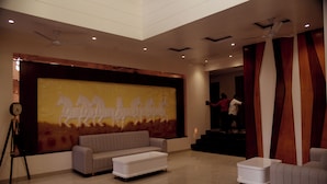 Un'ampia zona giorno con un grande affresco, un divano, un tavolino da caffè e una scala che conduce a un piano superiore.