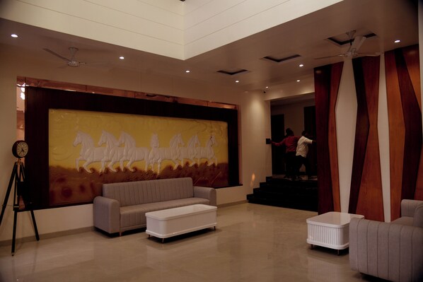 A spacious living area with a large wall mural, a sofa, a coffee table, and a staircase leading to an upper level. - The shark inn Residency (Huzur)