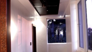 Una moderna camera d'albergo con un'ampia finestra, un letto e un soffitto in legno.