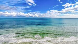 Una spiaggia con acque calme e un cielo azzurro luminoso.