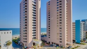 Two high-rise buildings with a beach view, a parking area, and a small pool. - Palms Resort #1704: 2  BR, 2.5  BA Condominium in Myrtle Beach, Sleeps 6 (Myrtle Beach)