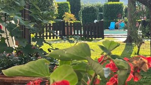 Een tuin met een houten omheining, een zwembad en uitzicht op bergen.