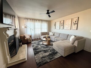 A living room with a fireplace, a sofa, a coffee table, and a ceiling fan. - Cozy 3-bedroom house in Duncan SC (Duncan)