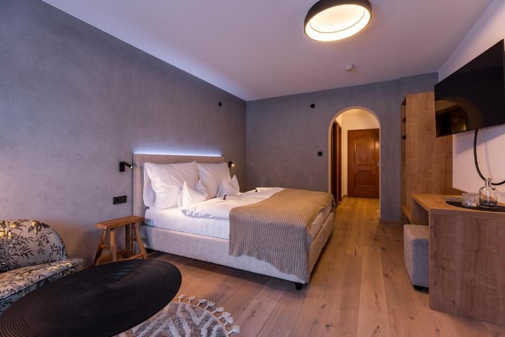 Une chambre à coucher comprenant un lit, une table de chevet et un bureau avec une chaise.