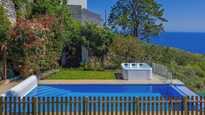 A swimming pool with a wooden fence, a hot tub, and a view of the ocean. - Sea Sky House By Holiday Rental Madeira (Ribeira Brava)