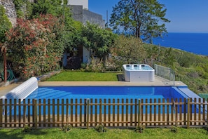 A swimming pool with a wooden fence, a hot tub, and a view of the ocean. - Sea Sky House By Holiday Rental Madeira (Ribeira Brava)