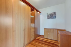 A room with wooden flooring, a wardrobe, a cabinet, and a framed picture on the wall. - Sea Sky House By Holiday Rental Madeira (Ribeira Brava)