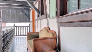 A wooden bench with a cushion, a wooden railing, and a window with a green door. - La Perle du Ried N° 7 near Europapark - Typical Alsatian dovecotes (Boofzheim)