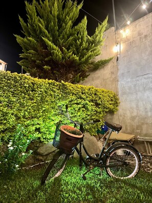 A bicycle parked against a wall with a hedge and a tree in the background. - Casa Viento - Private Pool, Garden & BBQ (San Pedro La Laguna)