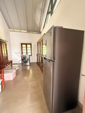 A kitchen with a stainless steel refrigerator, a washing machine, and wooden cabinets. - VILLA KOBEIMALHÉNA, Matara
Spacious 3-bedroom colonial villa with private pool. (Sulthanagoda)