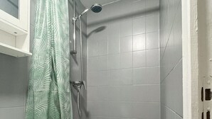 Un baño con ducha, lavamanos e inodoro.