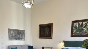 A bedroom with a bed, a sofa, a chandelier, and two paintings on the wall. - Dimora dei Marchesi: noble palace in the heart of Naples with 4 elegant suites (Napoli)
