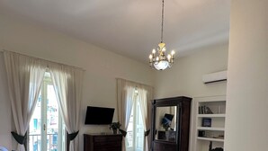 A bedroom with a bed, a dresser, a TV, a mirror, and a chair. - Dimora dei Marchesi: noble palace in the heart of Naples with 4 elegant suites (Napoli)