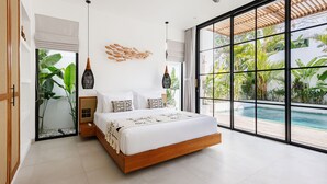 Camera da letto moderna con un grande letto, una ventola a soffitto e vista su una piscina.