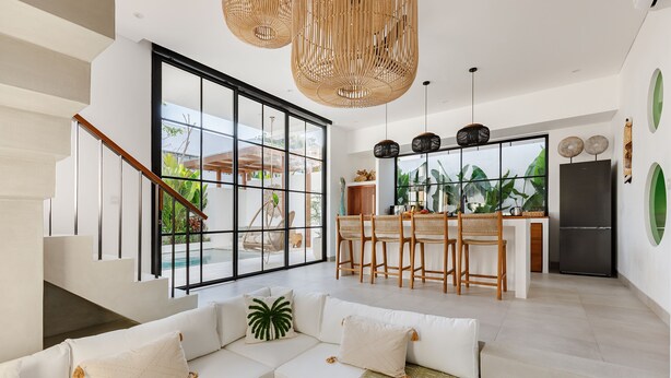 A modern kitchen with a large island, white cabinetry, and a black refrigerator. - Family Nest 2BR Villa with pool and balcony (Kabupaten Badung)