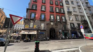 Un coin de rue avec un immeuble rouge, un immeuble blanc et une enseigne indiquant un restaurant.