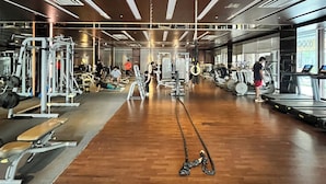 A gym with wooden flooring, exercise equipment, and mirrors. - Cozy 1-bedroom apartment with AC and golf course access (Gahunje)