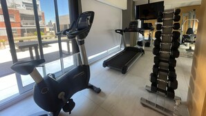 A gym with exercise equipment, a treadmill, and a weight rack. - Apartment in Nuñez (Buenos Aires)