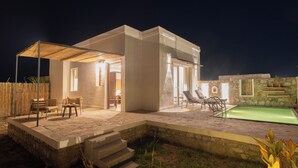A modern house with a swimming pool, outdoor seating, and a covered patio area. - Vanthra Vilas (Bali)
