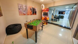 A room with a foosball table, a bean bag, and a wall with horse paintings. - 5BR by Lleras Park w Arcade & Foosball (Medellin)