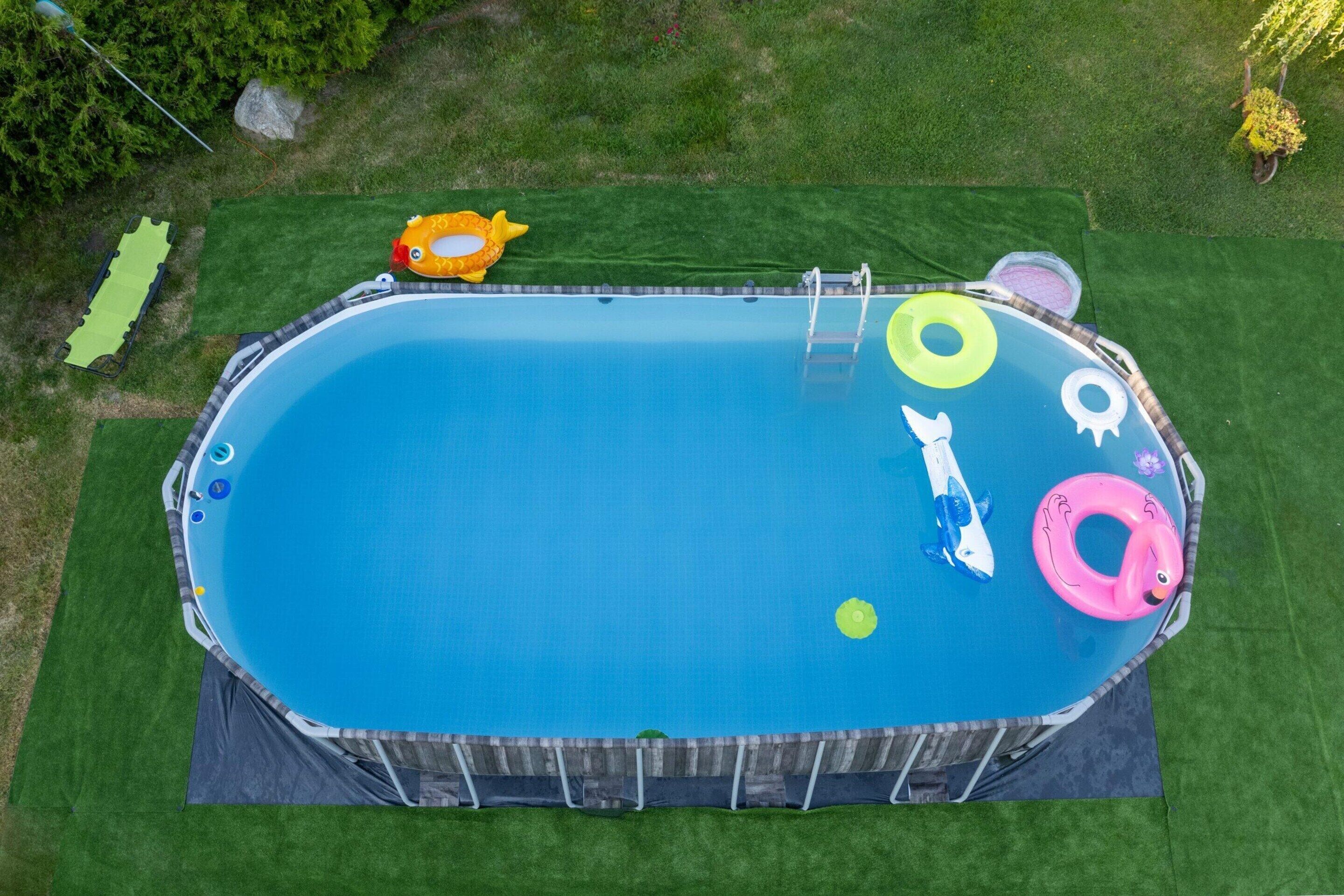 Ein oberirdischer Swimmingpool mit aufblasbaren Spielzeugen und einer Leiter.