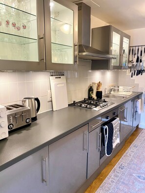 Eine moderne Küche mit Edelstahlgeräten, einem Gasherd und einem eingebauten Backofen.