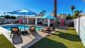 A backyard with a swimming pool, lounge chairs, and a covered patio area. - The Desert Bloomhouse | Heated Pool |Sleeps 12 (Scottsdale)