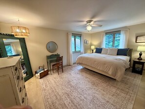 Ein Schlafzimmer mit einem Bett, einem Schreibtisch, einem Stuhl, einem Deckenventilator und einem Fenster.