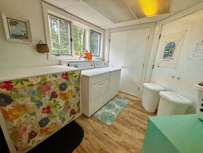 A compact kitchen with a sink, stove, and a window overlooking greenery. - Pemaquid Trail Gem: Water Views + Huge Deck + Private Beach Access (Bristol)