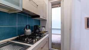 Cozinha com fogão a gás, chaleira e cafeteira.