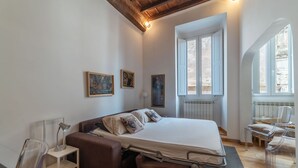 Quarto com cama, mesas de cabeceira, escrivaninha e cadeira.