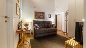 Uma sala de estar aconchegante com um sofá marrom, uma mesa de centro de madeira e uma TV em um móvel.