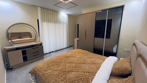 Um quarto com cama, penteadeira, espelho e guarda-roupa.