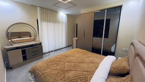 Un dormitorio con cama, cómoda, espejo y armario.