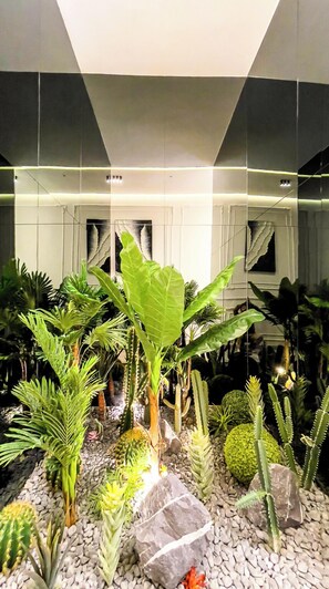 Un jardin intérieur moderne, agrémenté de diverses plantes et de rochers.