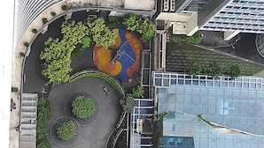 Luchtbeeld van een modern gebouw met een dakbostuin, een circulair plein met zitplaatsen en een parkeerplaats.