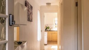 A hallway with a doormat that reads "It takes a village to build a home." -  1 bedroom 1 bathroom apartment in a quiet street in the heart of Chelsea, (London)