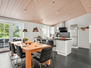 A modern kitchen with a central island, black chairs, and pendant lights. - "Marjatta" - 3.2km from the sea by Interhome (Blåvand)
