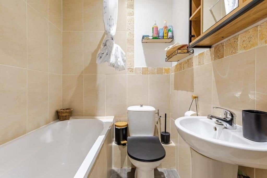 A bathroom with a bathtub, toilet, and sink.