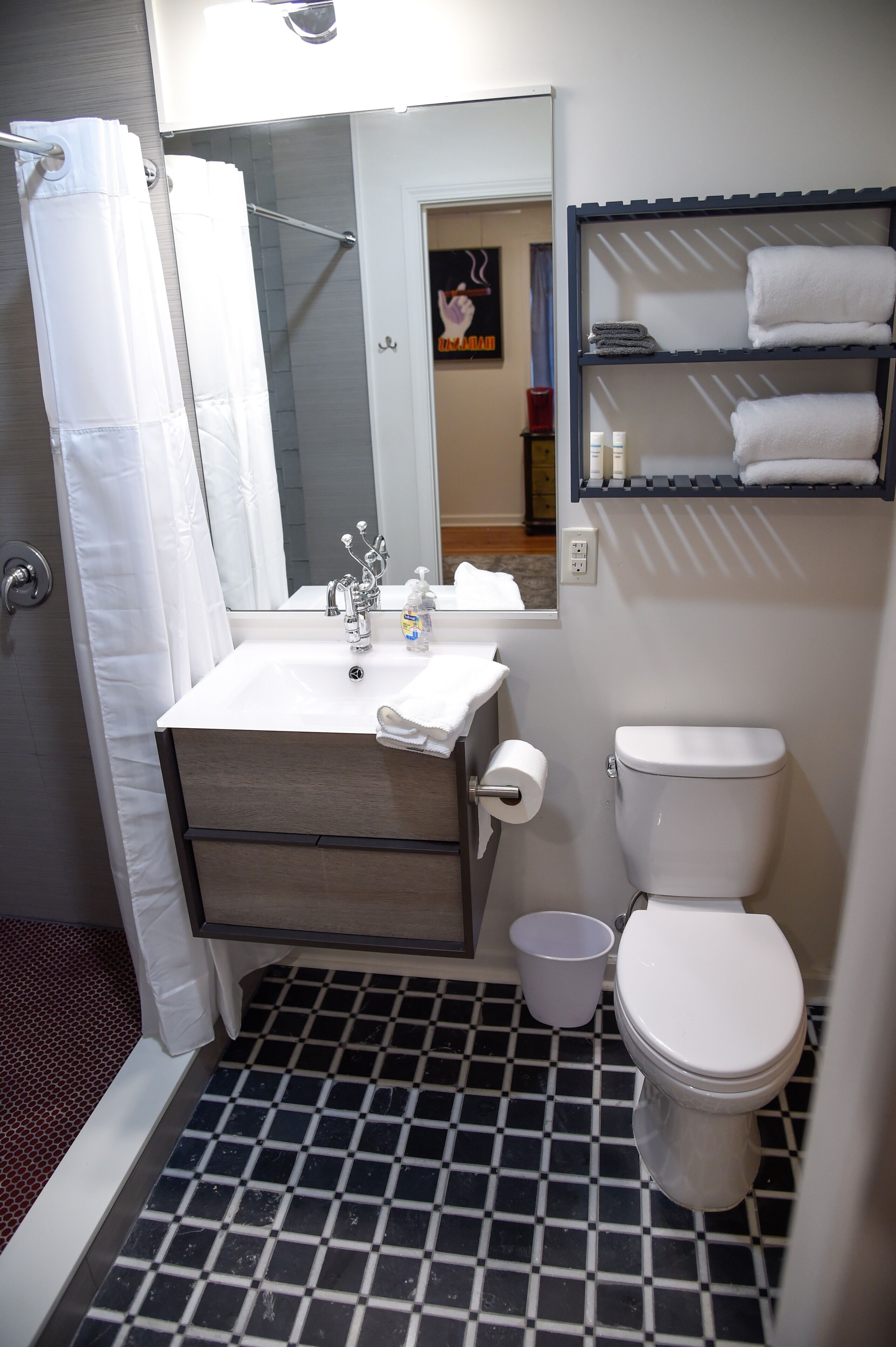 Une salle de bain équipée d’une douche, de toilettes, d’un lavabo et d’un miroir.