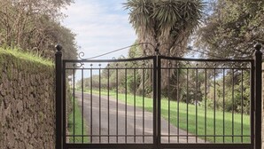 A gated entrance with a paved path leading to a road. - Casa Pino-private family villa with pool in Corfu, close to beaches/water park (Corfu)