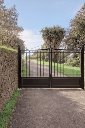 A gated entrance with a paved path leading to a road. - Casa Pino-private family villa with pool in Corfu, close to beaches/water park (Corfu)
