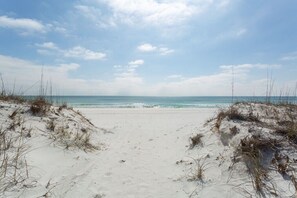Une plage avec des dunes de sable et une vue dégagée sur l’océan.