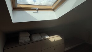 Un tragaluz en una habitación con piso de madera y un mueble de almacenaje empotrado debajo.