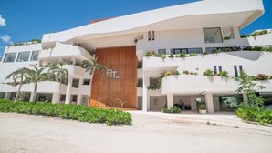 Ein modernes Hotel mit geschwungener Fassade, zahlreichen Balkonen mit Bepflanzung und einem markanten Eingang.