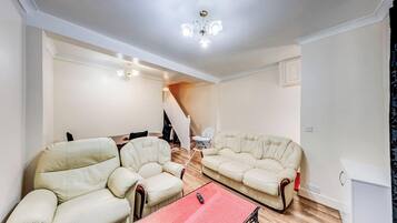 A living room with two sofas, a coffee table, and a staircase leading to another level.
