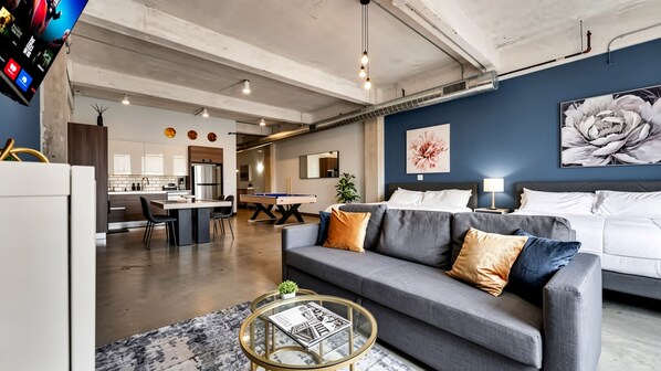 A modern living room with a grey sofa, a coffee table, and a pool table. - Dallas Skyline View Flat w/ Pool, Gym & Free Parking (Dallas)