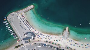 An aerial view of a coastal area with a pier, beach, and boats. - Cozy 3-bedroom house for 5 people  in exclusive Jadranovo next to the sea (Jadranovo)
